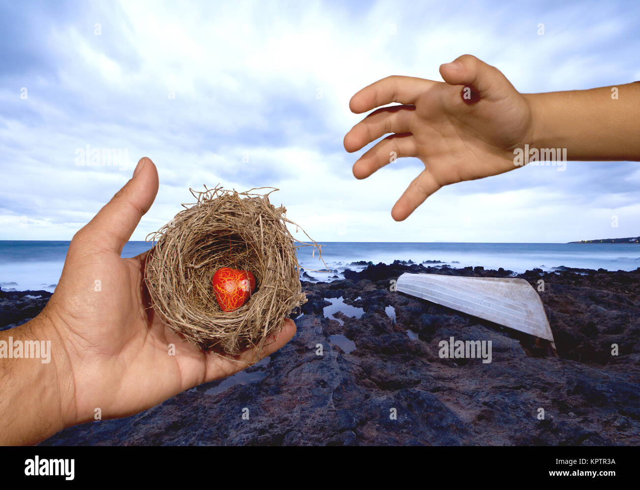 Le mani umane mantenere un nido naturale con un cuore rosso interno e un bambino cerca di raggiungere questo nido. I legami familiari, protezione, sicurezza, di speranza, di solidarietà. Foto Stock
