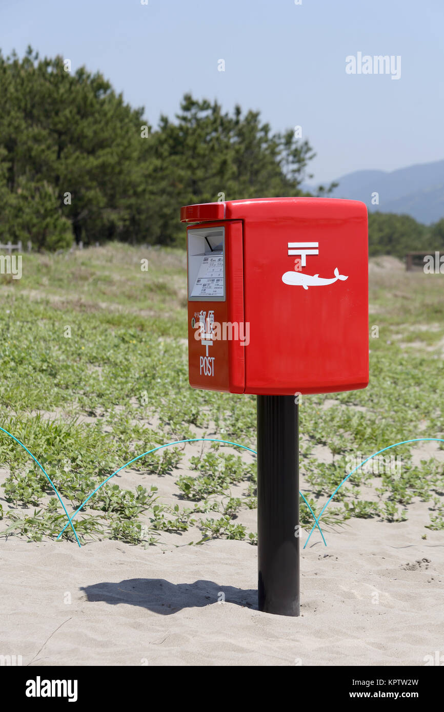 Rosso giapponese casella di posta su di una spiaggia di sabbia Foto Stock