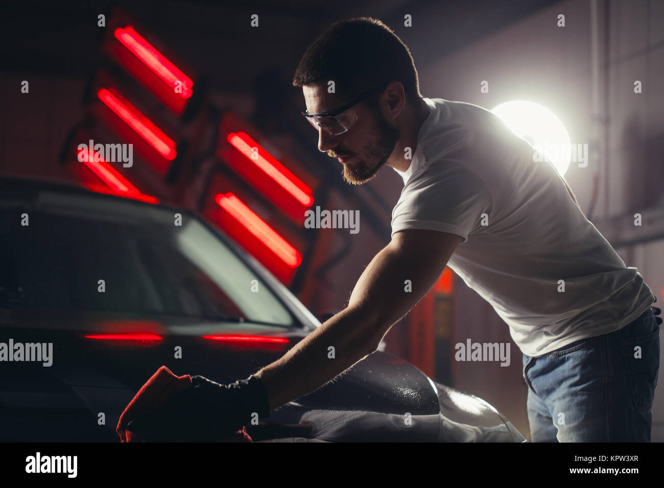 Dettagli auto - l'uomo detiene la microfibra in mano e leviga la vettura Foto Stock