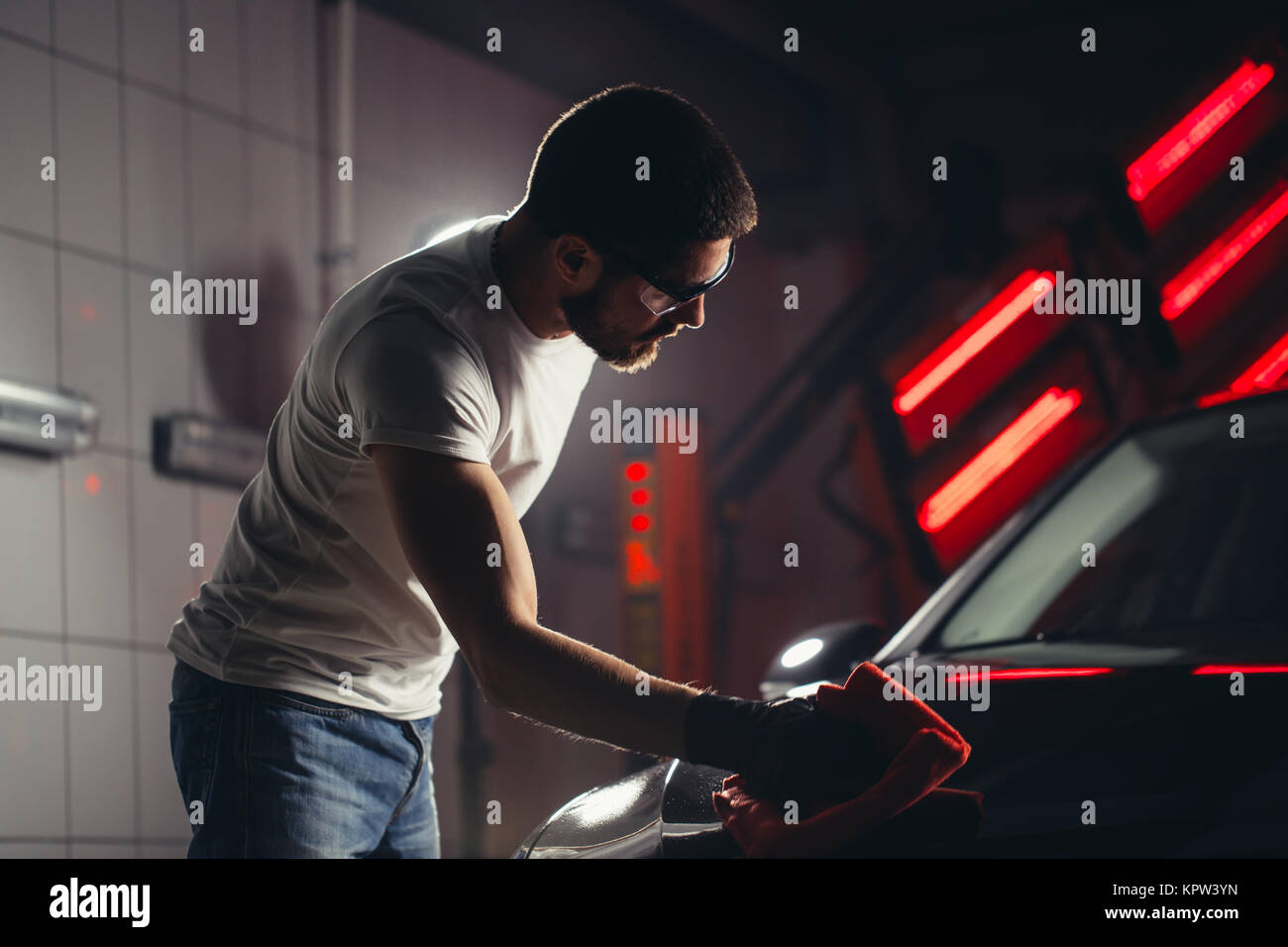 Uomo Macchina di pulizia con un panno in microfibra, auto che dettaglia o concetto valeting Foto Stock