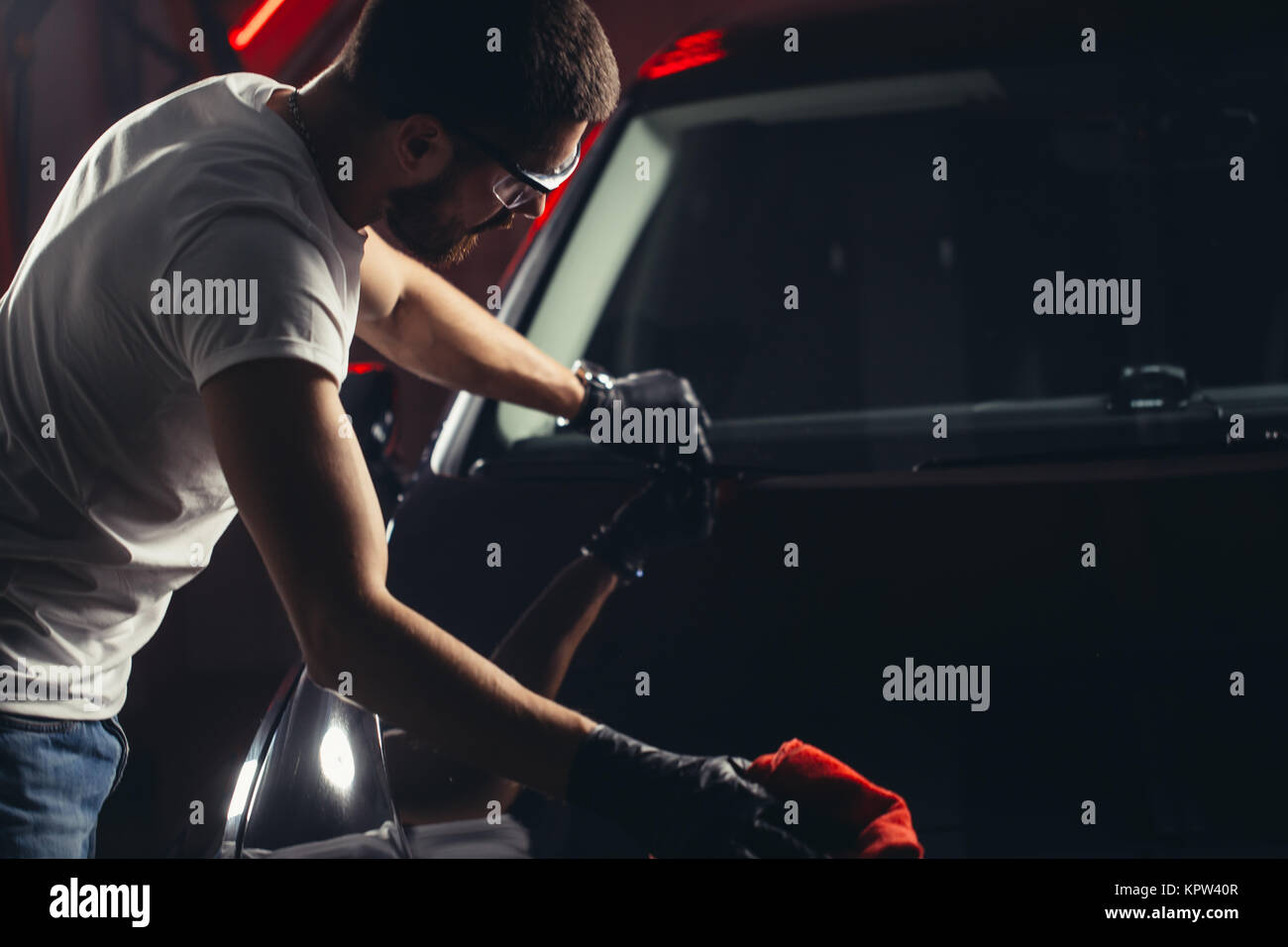 Uomo Macchina di pulizia con un panno in microfibra, auto che dettaglia o concetto valeting Foto Stock