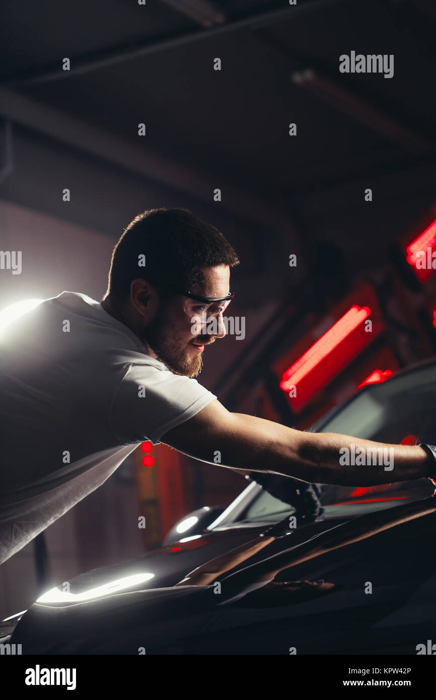 Uomo Macchina di pulizia con un panno in microfibra, auto che dettaglia o concetto valeting Foto Stock