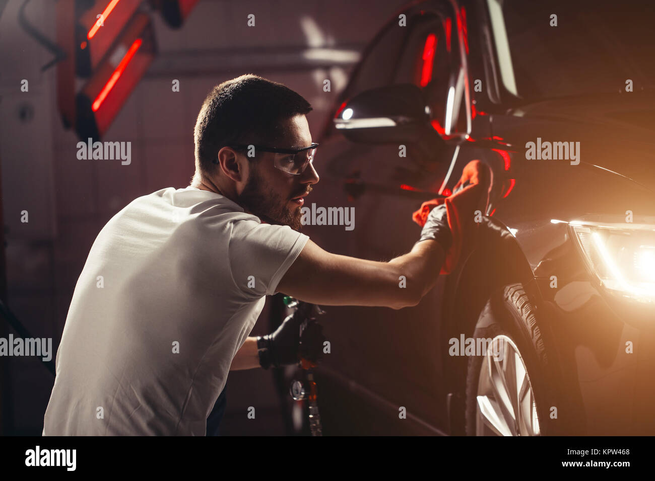 Uomo Macchina di pulizia con un panno in microfibra, auto che dettaglia o concetto valeting Foto Stock