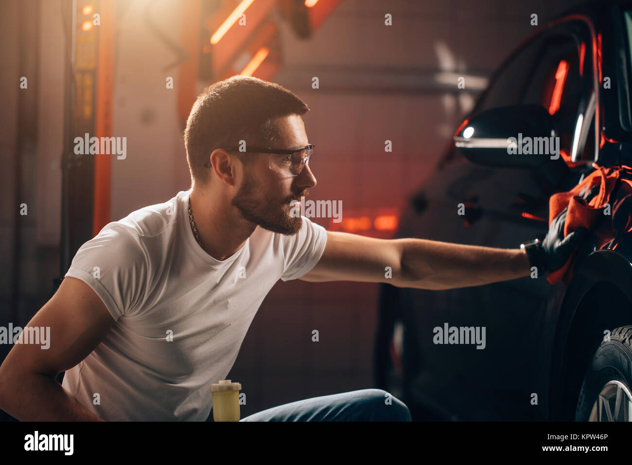 Dettagli auto - l'uomo detiene la microfibra in mano e leviga la vettura Foto Stock