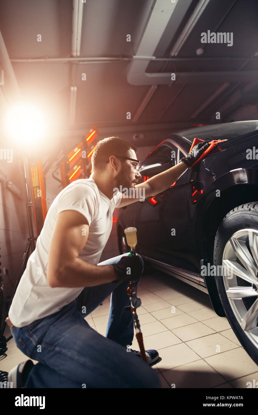 Uomo Macchina di pulizia con un panno in microfibra, auto che dettaglia o concetto valeting Foto Stock