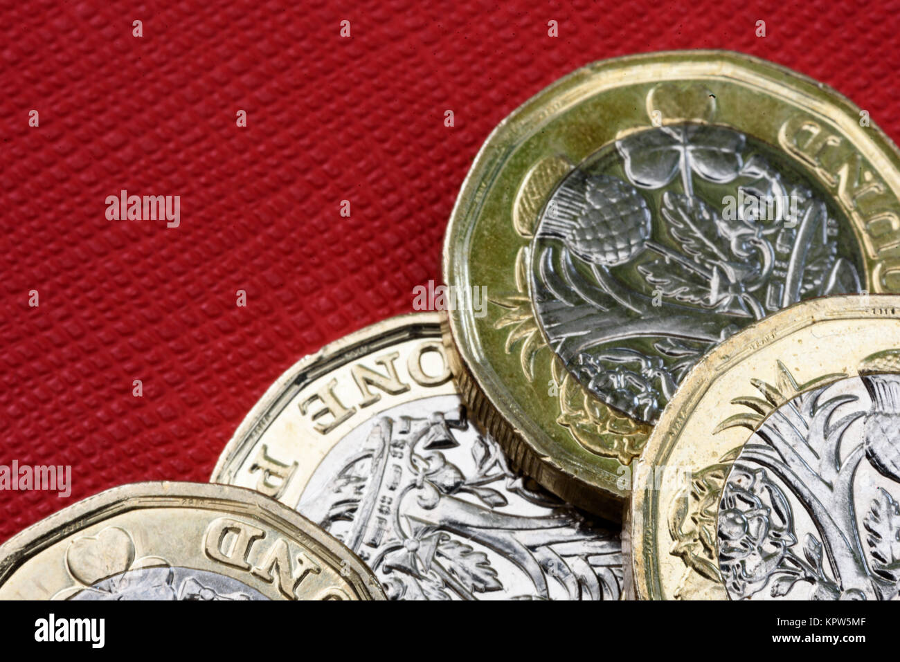 Nuovo lucido sterlina britannica valuta Moneta di argento e oro su sfondo rosso. Le monete sono progettati per fermare la contraffazione di denaro in inglese Foto Stock