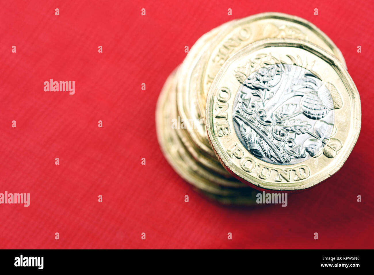 Nuovo lucido sterlina britannica valuta Moneta di argento e oro su sfondo rosso. Le monete sono progettati per fermare la contraffazione di denaro in inglese Foto Stock