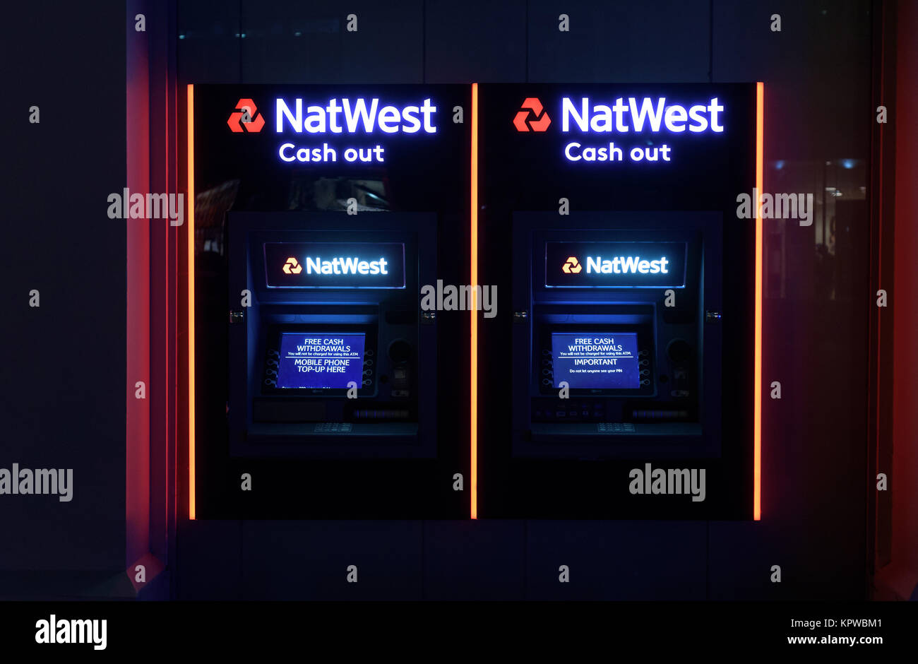 Due NatWest bank bancomat ATM di notte in luminosi colori al neon con nessuno fornendo 24 ora denaro gratuito Foto Stock