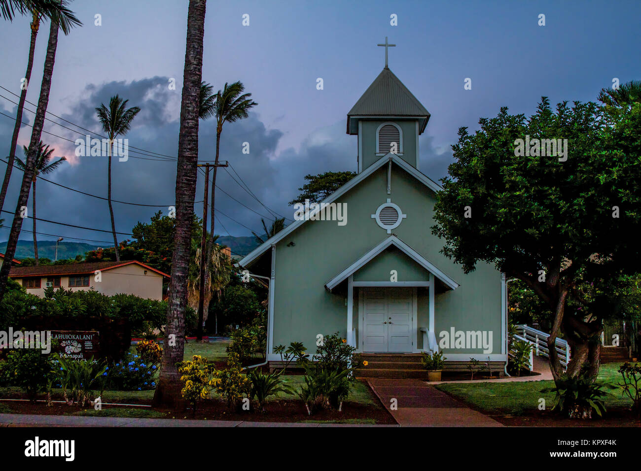 Le albe in Old Lahaina Town sulla storica Chiesa Hawaiiana sul lato ovest di Maui. Il cielo blu rende la strada per la tonalità di rosa tra le nuvole. Foto Stock