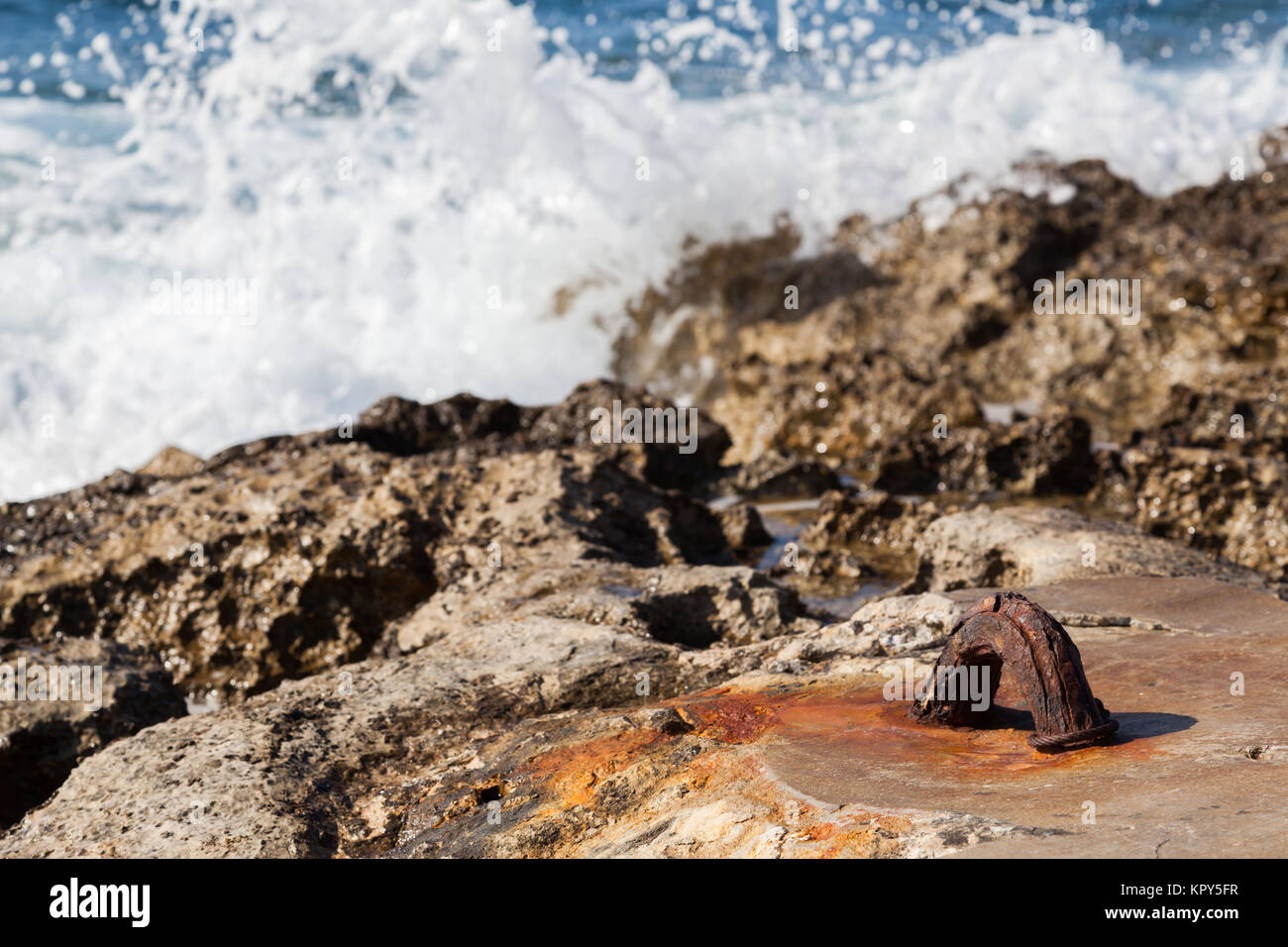 Onde smashing su un gancio in un roccioso sunny beach Foto Stock