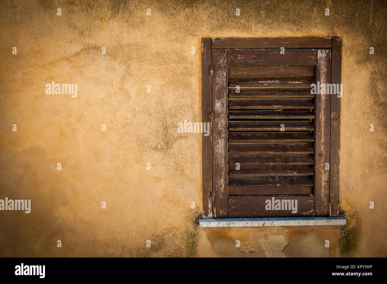 Chiude la finestra di legno su una antica casa gialla parete Foto Stock