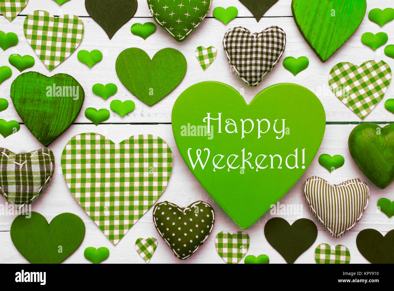 Cuore verde Texture con testo in inglese Happy Weekend. Bianco sullo sfondo di legno. Cuori di tessili che sono punteggiate e striato. Foto Stock