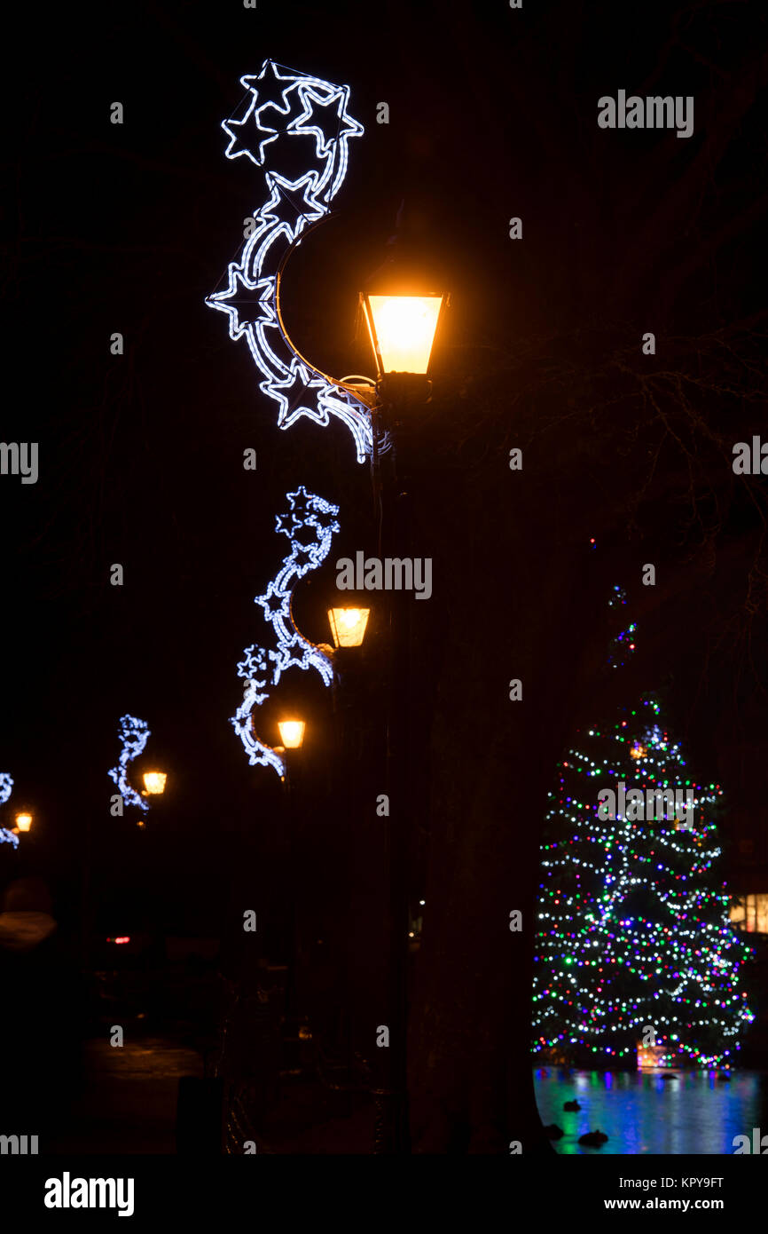 Strada di Natale decorazioni di luce di notte notte a Bourton sull'acqua, Cotswolds, Gloucestershire, Inghilterra Foto Stock