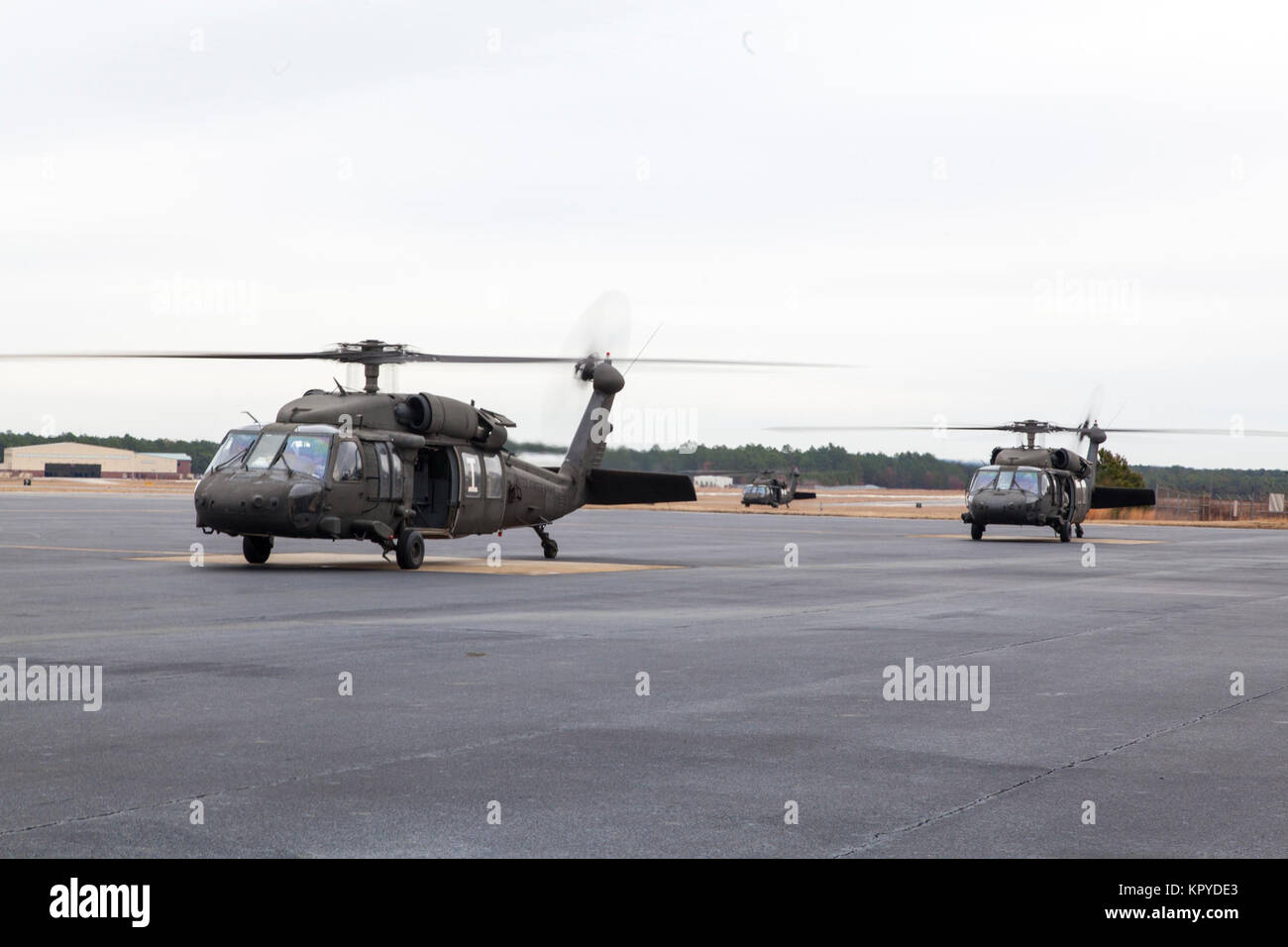 UH-60 Blackhawks attendere per i paracadutisti di carico durante il ventesimo annuale di Randy Oler Memorial il funzionamento del giocattolo goccia, a MacKall Army Airfield, North Carolina, 7 dicembre, 2017. Quest'anno, otto paesi partecipano ed essi includono; la Colombia, Canada, Lettonia, Paesi Bassi, Svezia, Italia, Germania e Polonia. Il funzionamento del giocattolo Drop, ospitato dall'U.S. Esercito degli affari civili e le operazioni psicologiche il comando (Airborne) è il più grande combinati airborne operazione condotta in tutto il mondo. L'evento consente di soldati la possibilità di allenarsi sul loro militari professionali di specialità, mantenere la loro airborne readine Foto Stock