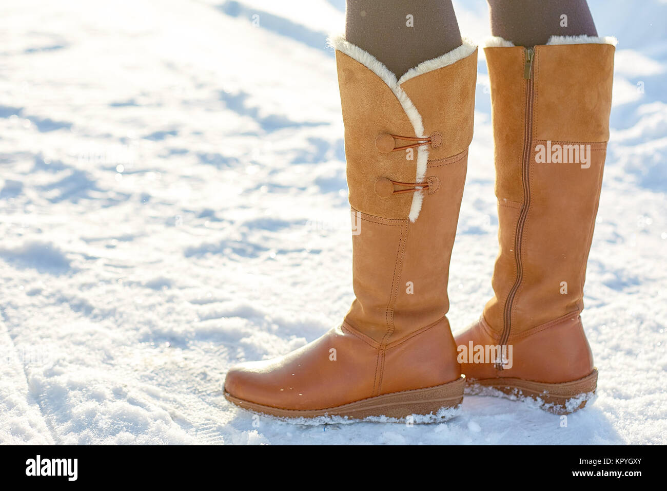 Gamba donna inverno marrone stivali di pelliccia di camminare sulla neve in  un parco d'inverno. Primo piano della suola di avvio a caldo Foto stock -  Alamy