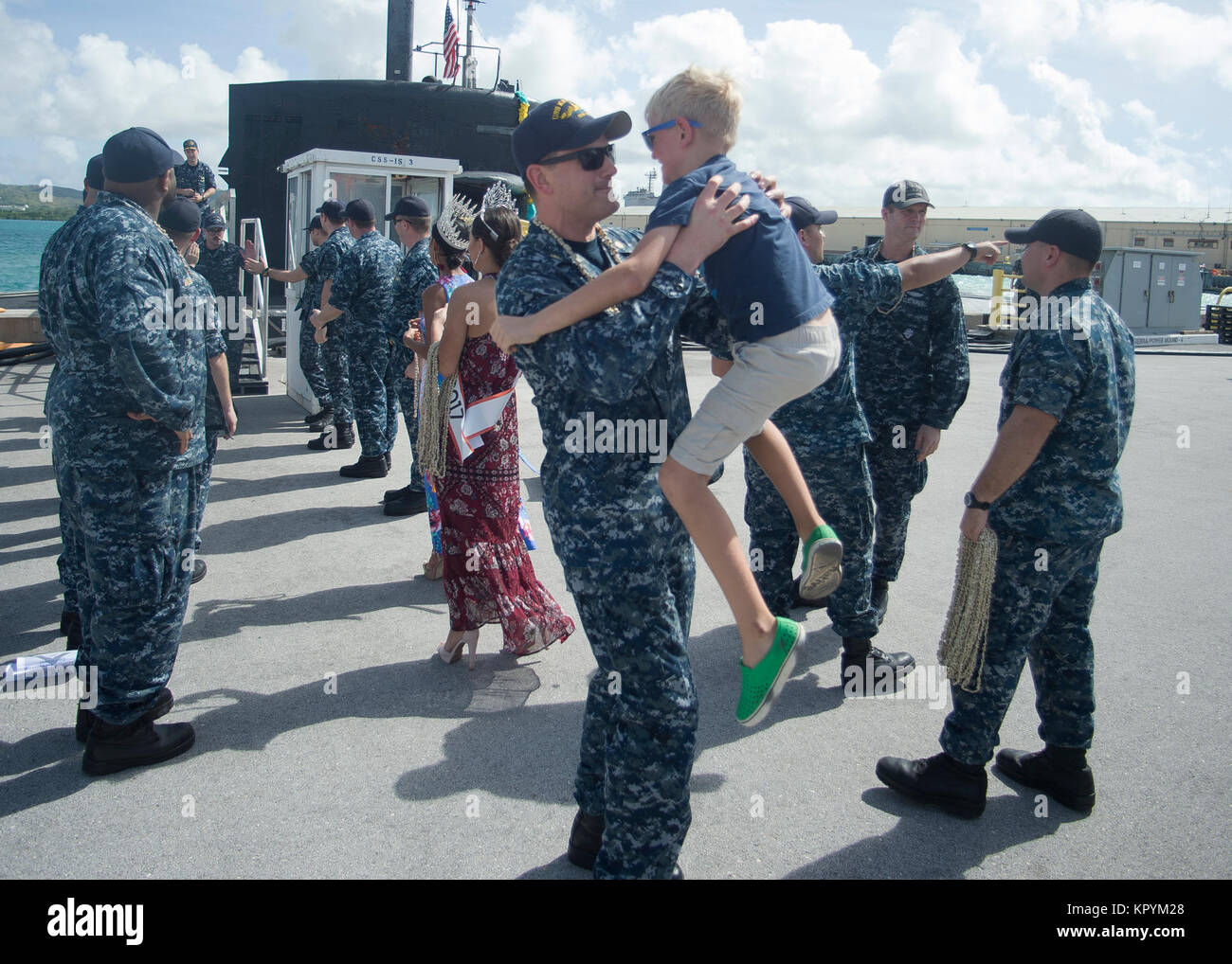 APRA HARBOR, Guam (dec. n. 15, 2017) Lt. La Cmdr. Patrick Tembreull, delegato di Los Angeles-class attack submarine USS Key West (SSN 722), è riunita con suo figlio Graham durante il sommergibile di homecoming celebrazione dopo quattro mesi di avanzamento-periodo di funzionamento nel Pacifico occidentale. Key West è uno dei quattro distribuita sottomarini homeported in Apra Harbor, Guam. (U.S. Navy Foto Stock