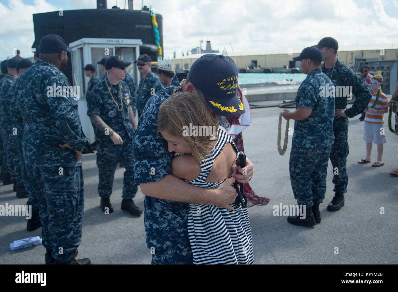 APRA HARBOR, Guam (dec. n. 15, 2017) della Cmdr. J. Grady Hill, comandante della Los Angeles-class attack submarine USS Key West (SSN 722), abbraccia la figlia Alex durante il sommergibile di homecoming celebrazione dopo quattro mesi di avanzamento-periodo di funzionamento nel Pacifico occidentale. Key West è uno dei quattro distribuita sottomarini homeported in Apra Harbor, Guam. (U.S. Navy Foto Stock