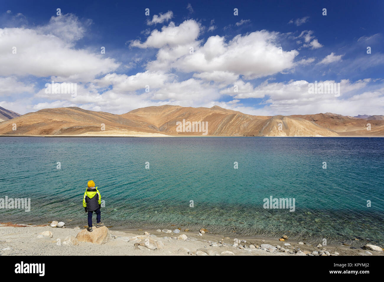 Giovane ragazzo caucasico permanente sulla riva del Tso Pangong lake, Ladakh, Jammu e Kashmir in India. Foto Stock