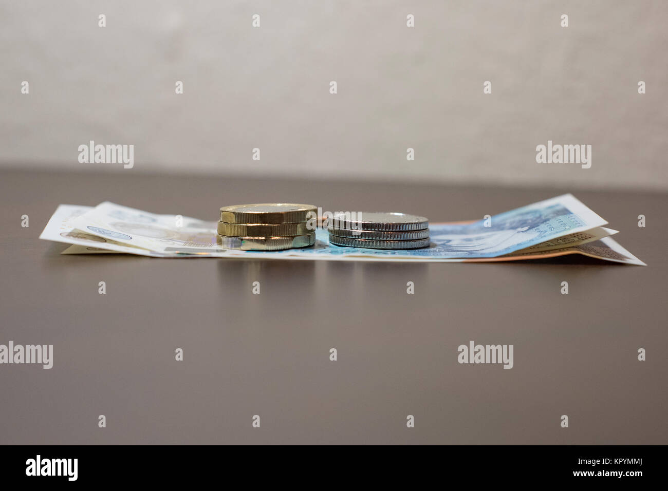 Nuova serie UK delle banconote e delle monete in euro - un £5 nota, due £10 note, tre £1 monete, tre £0.10 monete e un centesimo in background, £28.31 in totale Foto Stock