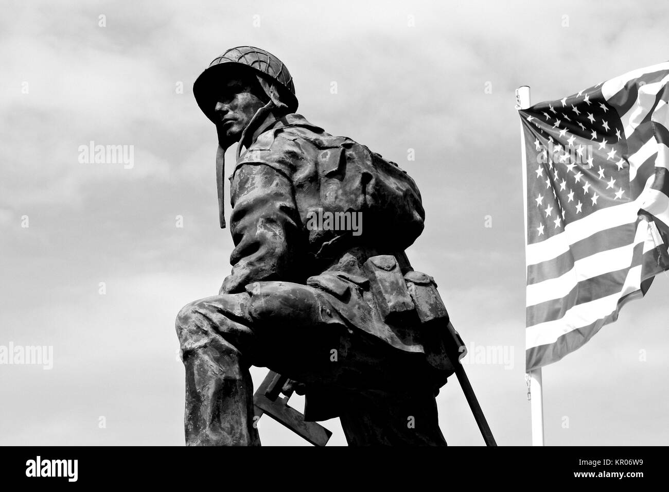 Statua di bronzo di un ferro da stiro a Mike, un soldato dell'esercito americano in possesso di una pistola con una bandiera degli Stati Uniti d'America. La Fiere Bridge, Sainte-Mere- Foto Stock