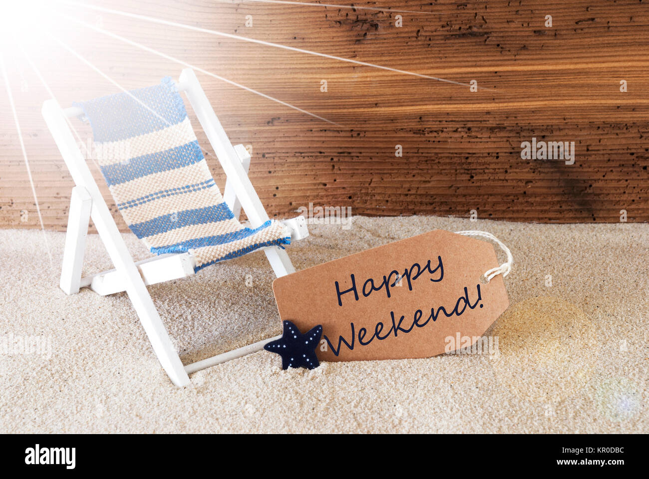 Sunny Estate Etichetta con sabbia e invecchiato Sfondo di legno. Testo inglese Happy Weekend. Sedia a sdraio per vacanza o sensazione di vacanza. Foto Stock