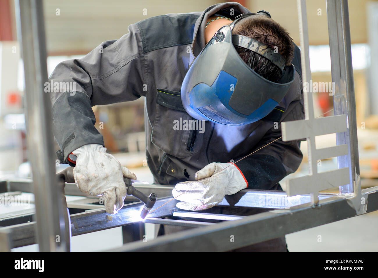 Uomo appoggiato sopra la saldatura Foto Stock
