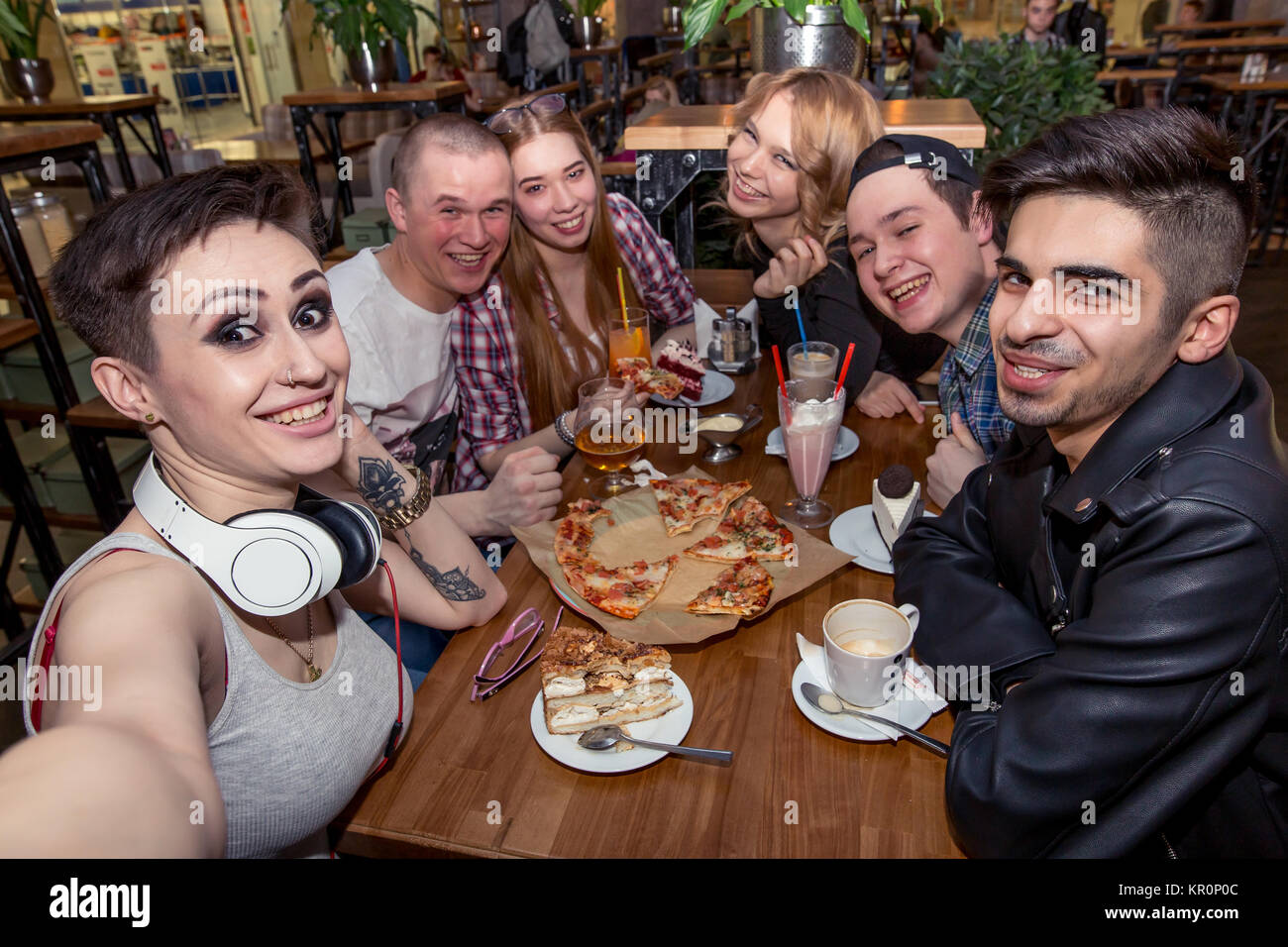 Gruppo di multirazziale giovani prendendo un selfie mentre mangiare la pizza Foto Stock