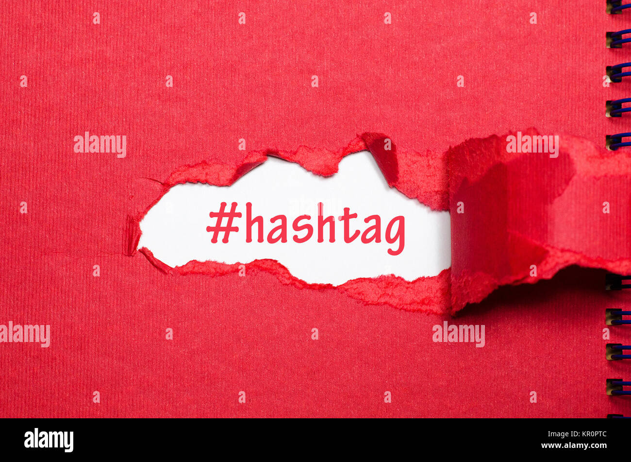 La parola hashtag che appaiono dietro di carta strappata Foto Stock