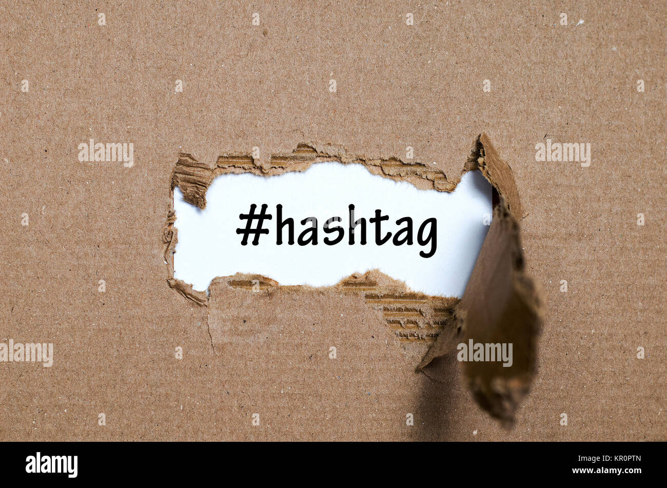 La parola hashtag che appaiono dietro di carta strappata Foto Stock