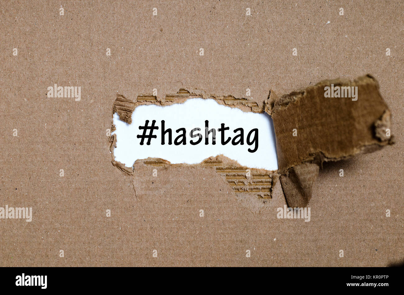 La parola hashtag che appaiono dietro di carta strappata Foto Stock