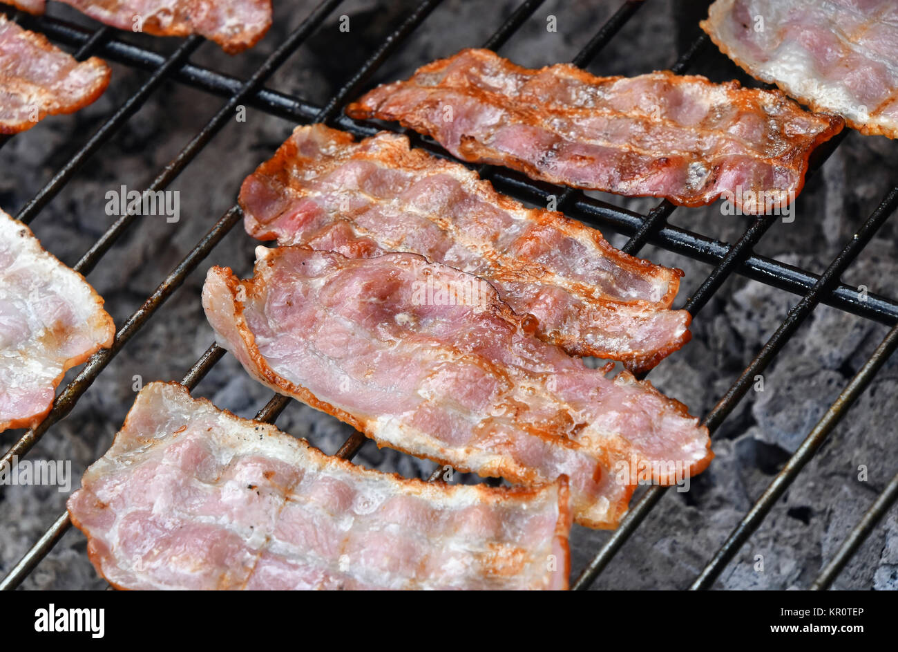 Croccanti fette di pancetta affumicata cotta sulla griglia per il barbecue Foto Stock