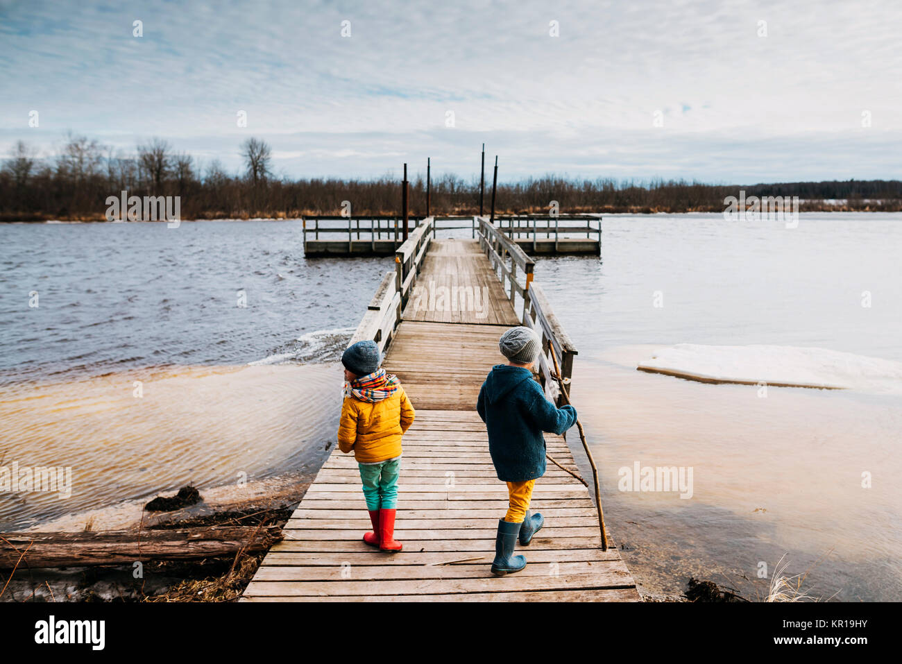 Due ragazzi in piedi su una dock su un lago ghiacciato Foto Stock