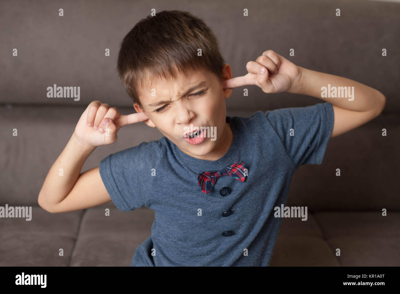 Ragazzo con le dita nei suoi orecchi Foto Stock