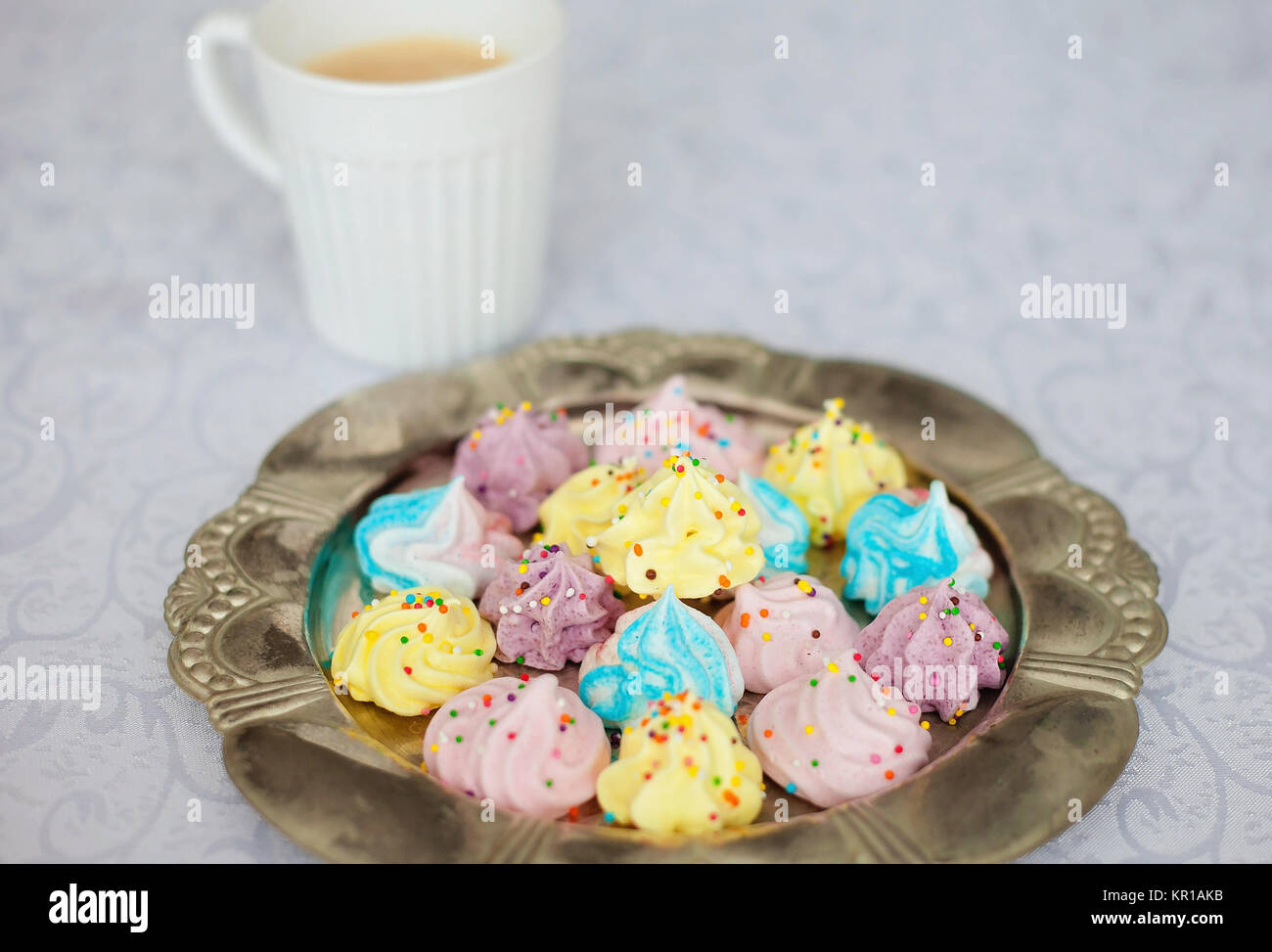 Tazza di caffè e un piatto di baci multicolore meringa Foto Stock