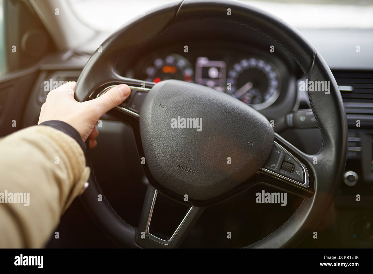 Utilizzando i pulsanti sul volante auto vicino. Premendo il pulsante su auto ruota Foto Stock