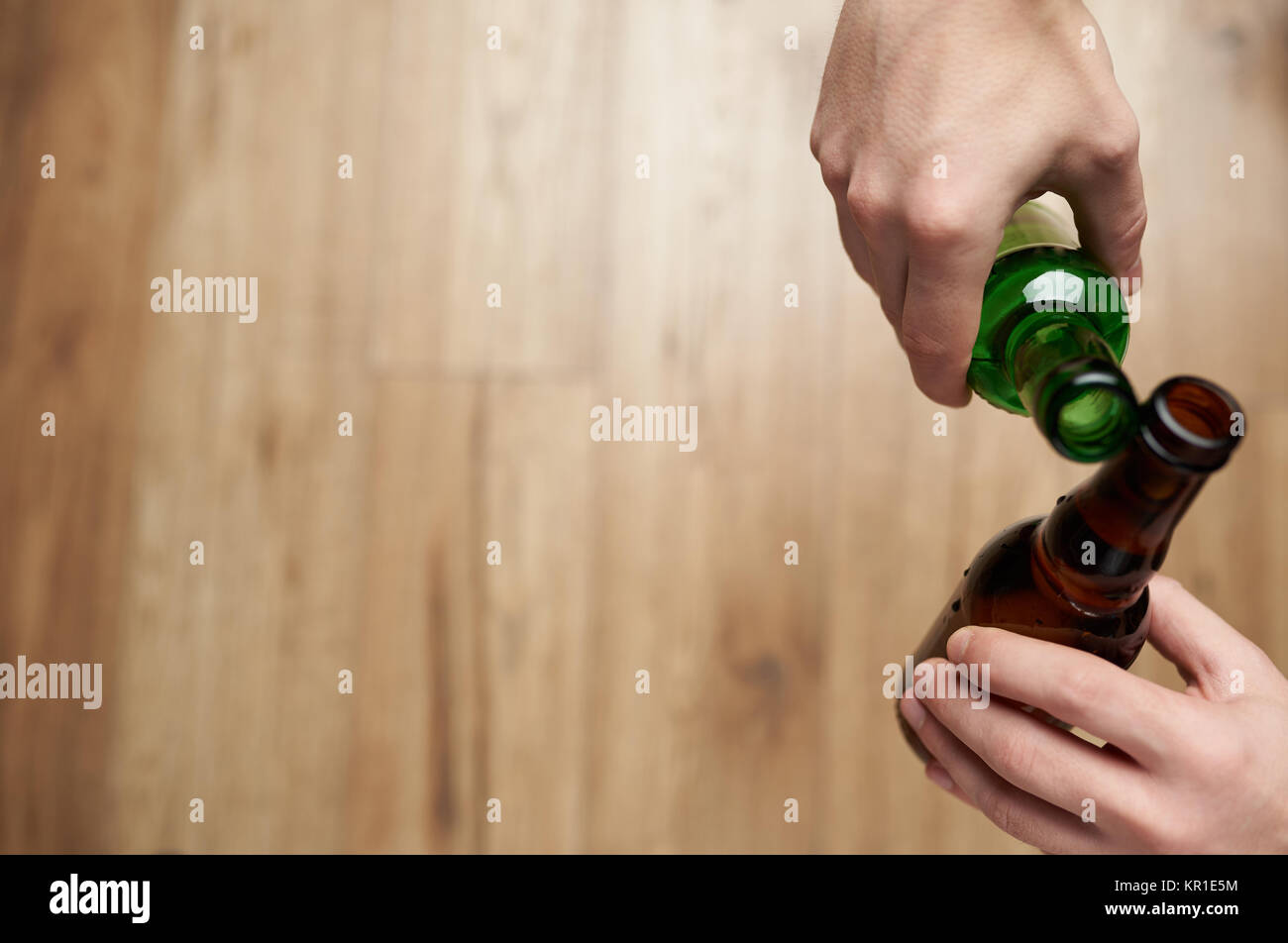 Consumo di alcool tema. Cheers con bottiglie di birra in mano sopra vista Foto Stock