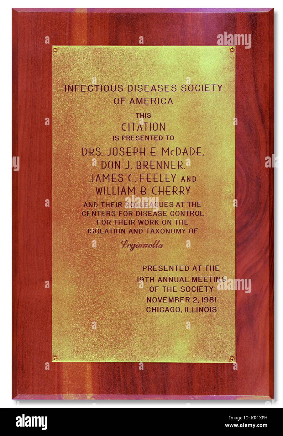 Questa placca è stato presentato ai membri del CDC per il loro lavoro sulla tassonomia e isolamento di Legionella pneumophila, 1981. La scoperta di batteri del genere Legionella è venuto nel 1976 quando un focolaio di polmonite a un American Legion convenzione ha portato a 29 morti. L'agente causativo, noto come Legionella pneumophia, è stato isolato e dato il proprio genere. Immagine cortesia CDC. Foto Stock