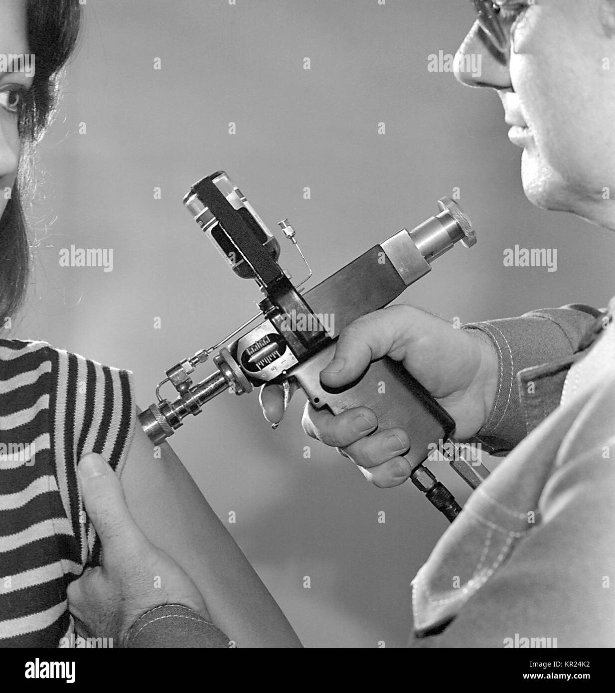 La somministrazione di un vaccino durante il 1976 New Jersey progetto di immunizzazione, per l'influenza A (influenza suina), 1976. IMGSETINF, uso di un iniettore a getto durante il 1976 New Jersey influenza un progetto di immunizzazione. 45 milioni di adulti negli Stati Uniti ha ricevuto un vaccino contenente il A/New Jersey/76 influenzavirus ("influenza suina" virus). Immagine cortesia CDC/Robert E. Bates. Foto Stock