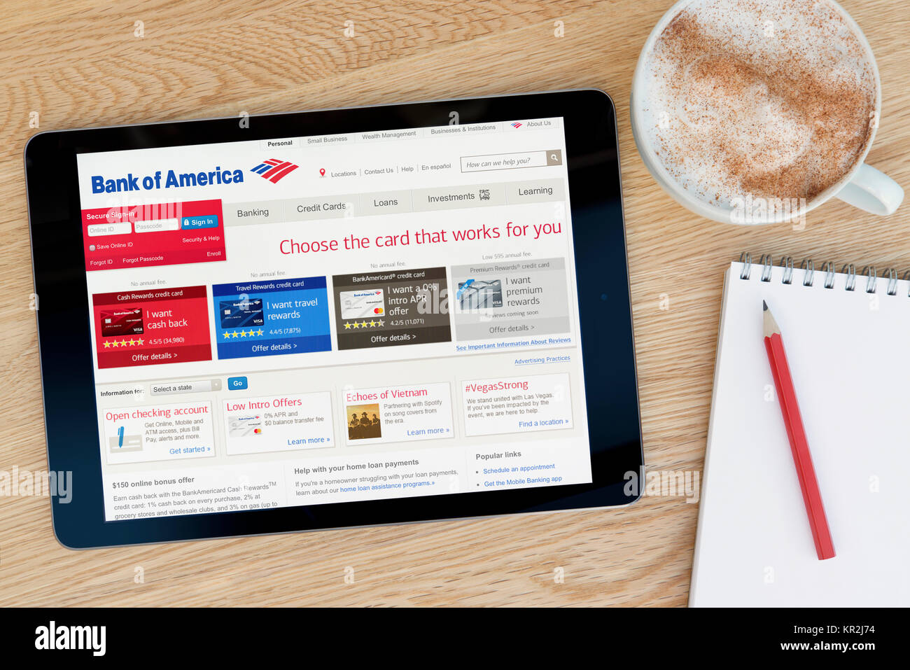 La Bank of America sito web su un iPad dispositivo tablet pc che si appoggia su una tavola di legno accanto a un blocco note e matita e una tazza di caffè (editoriale solo) Foto Stock