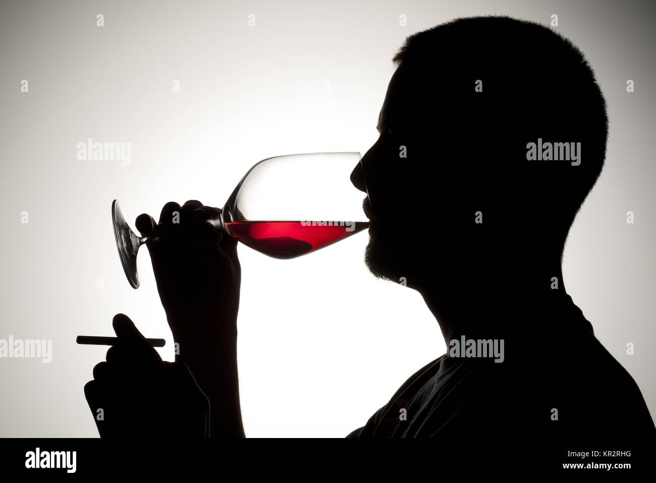 Silhouette di un uomo con la sigaretta e vino Foto Stock