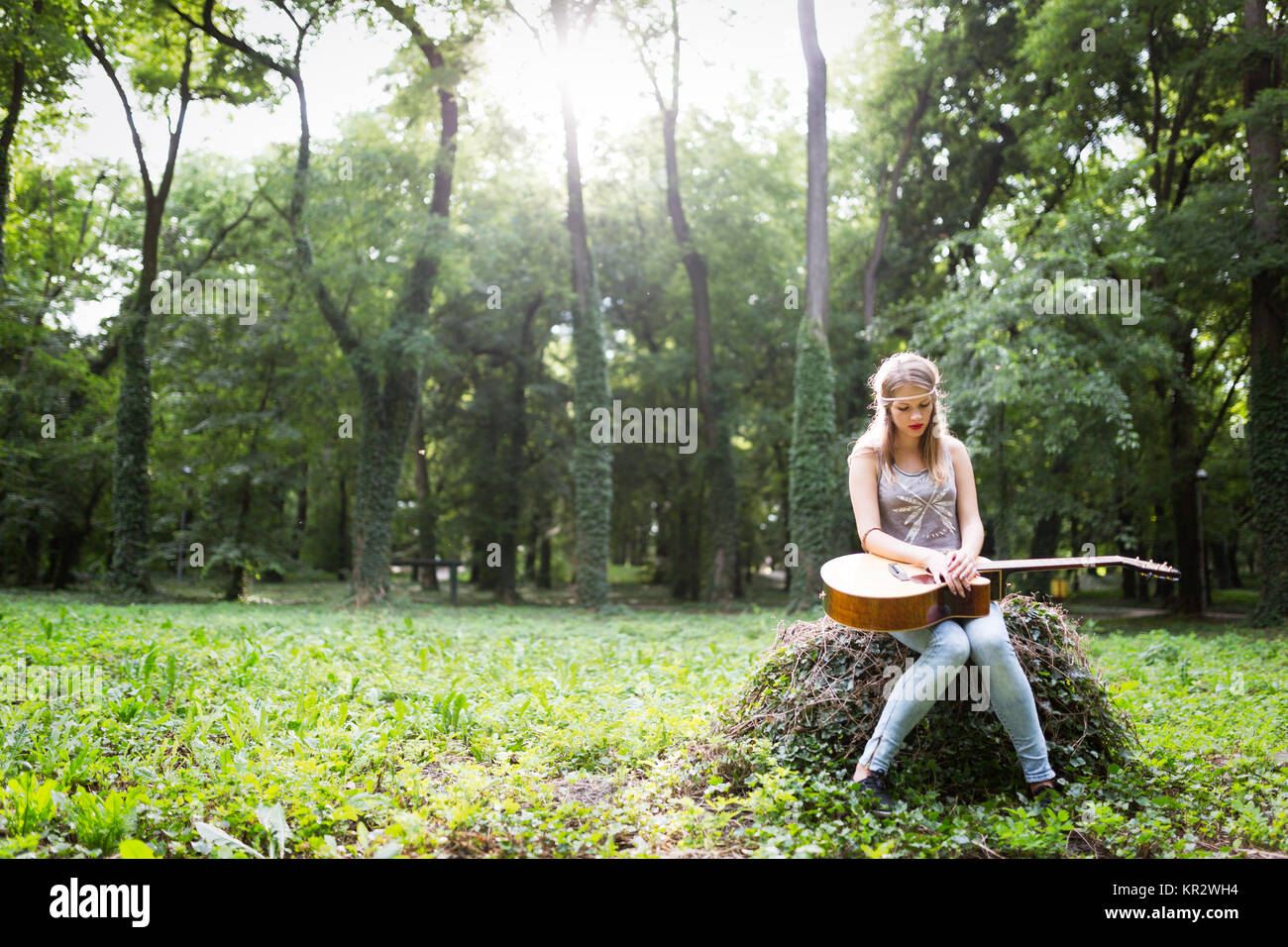 Heartbroken woman in natura con la chitarra Foto Stock