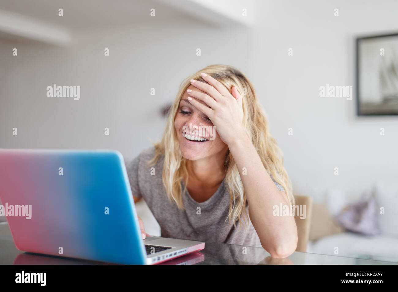 Donna bionda con laptop dimenticare qualcosa di acquistare nel negozio online, facepalm Foto Stock