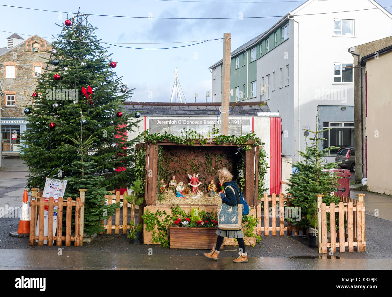 Albero di natale e il presepe con lady camminare davanti a Skibbereen, County Cork, Irlanda con copia spazio. Foto Stock