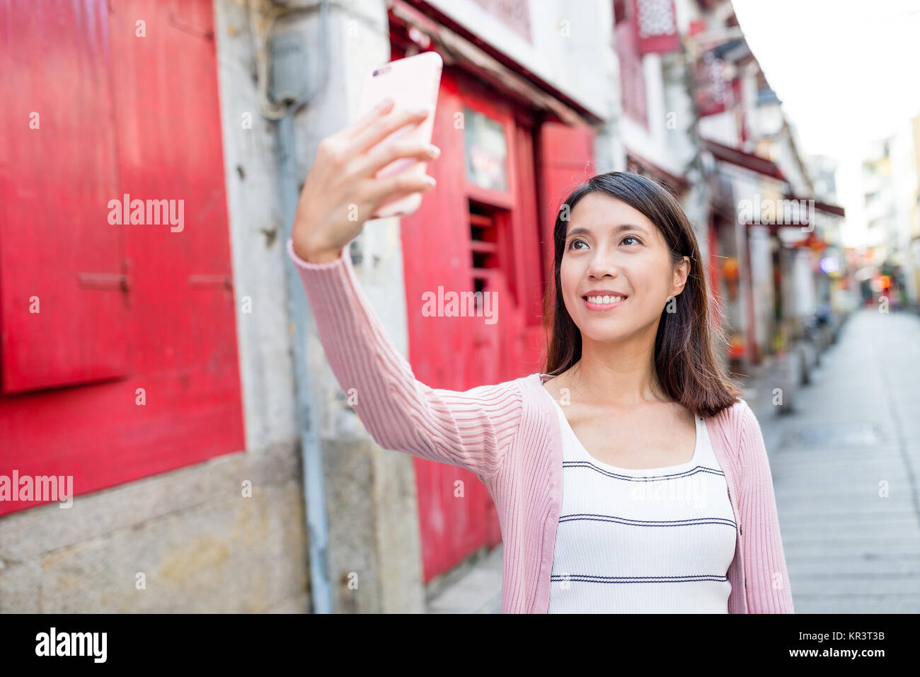 Donna prendendo selfie da smart phone in Rua da felicidade Foto Stock