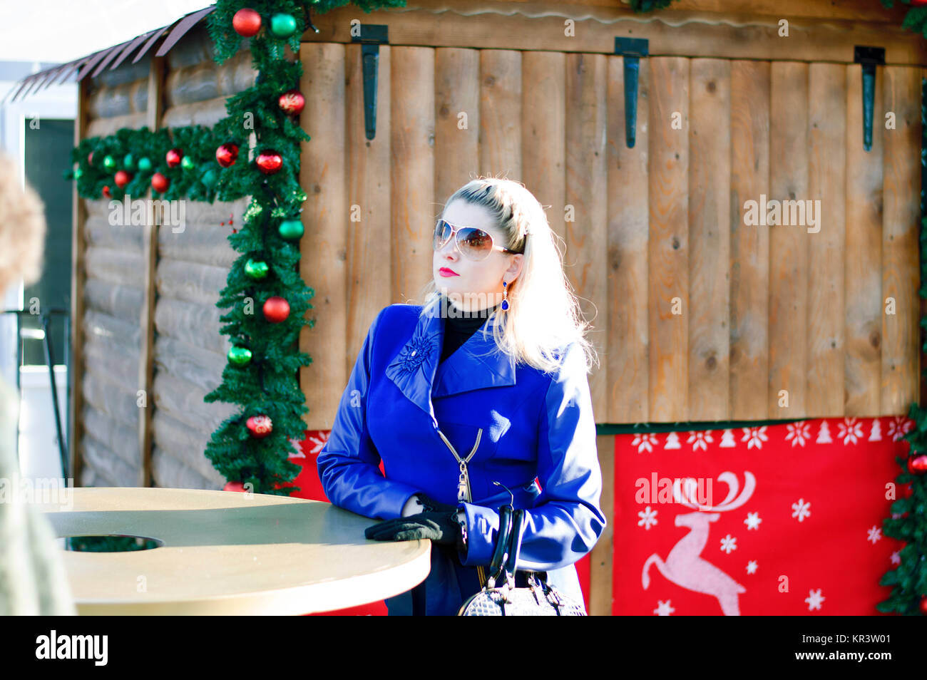 La bella donna a un tavolo contro il legno decorate in casa per Natale Foto Stock