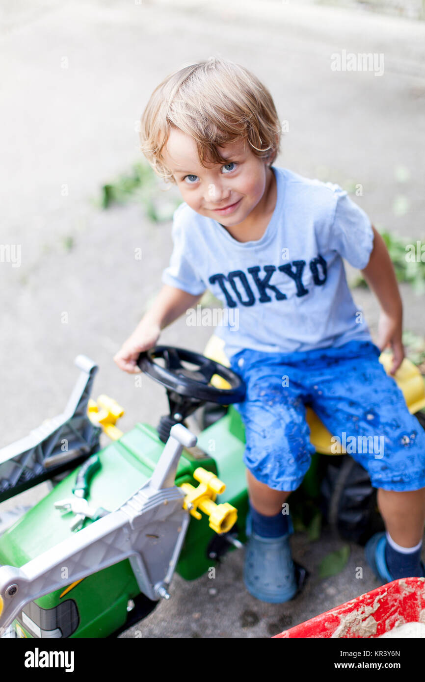 Little Boy sul suo trattore giocattolo Foto Stock