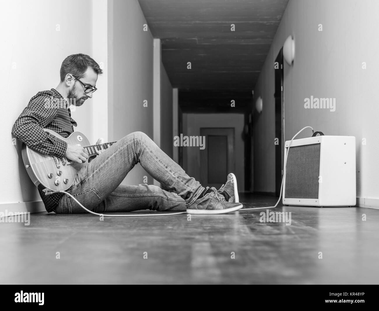 L'uomo suonando una chitarra elettrica in un corridoio Foto Stock