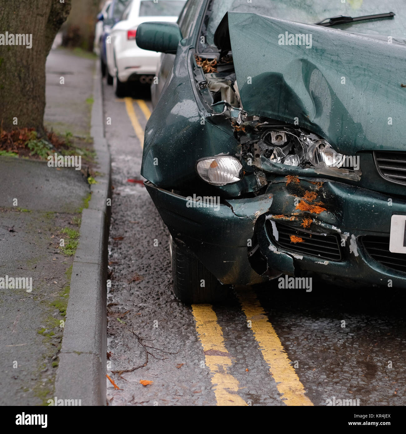 Dicembre 2017 - Albero 1 - Auto 0, vecchio verde auto danneggiato dove si imbatté in una struttura ad albero Foto Stock