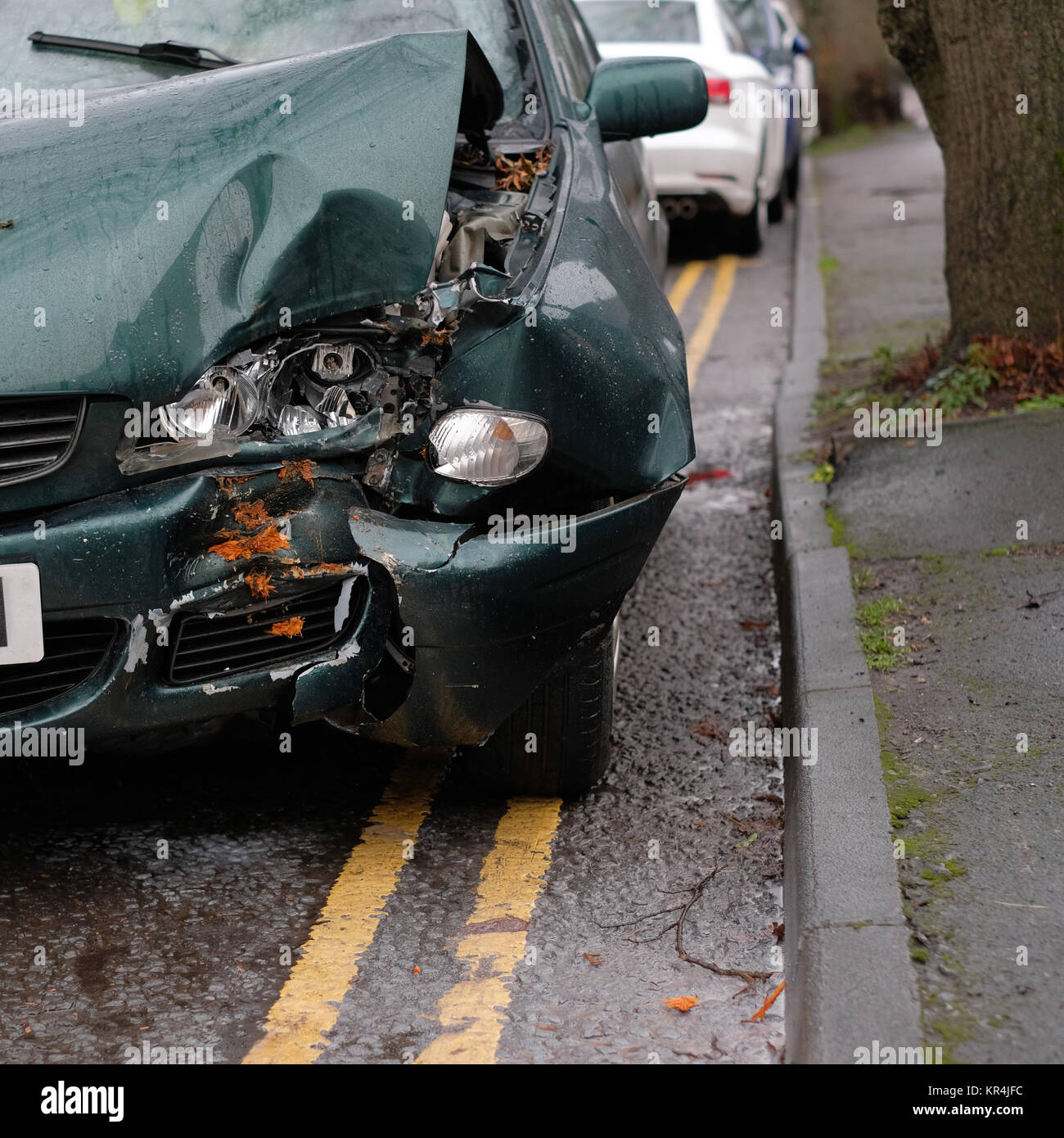 Dicembre 2017 - Albero 1 - Auto 0, vecchio verde auto danneggiato dove si imbatté in una struttura ad albero Foto Stock
