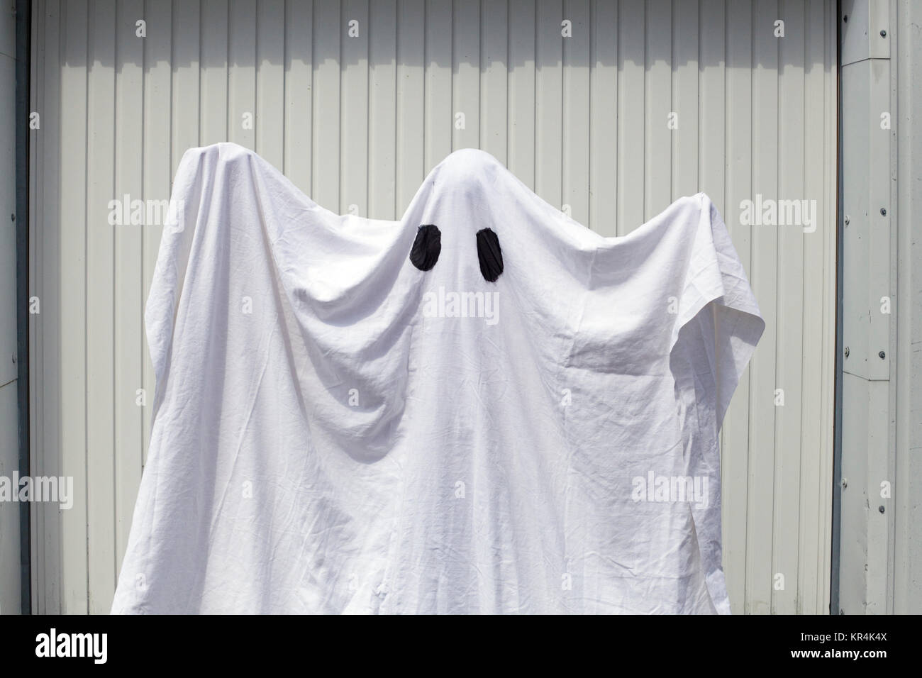 Un fantasma bianco di fronte a una porta di garage Foto Stock